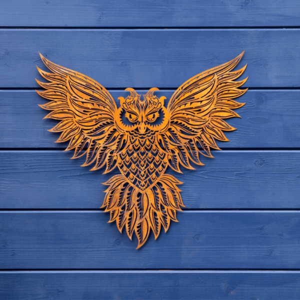 Owl garden wall plaque rusty metal. Decorative cut out metal work showing an owl displaying its wings